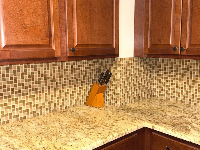 room details with light stone countertops and backsplash