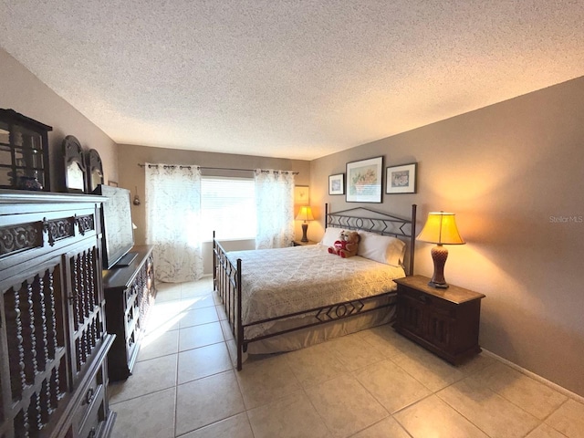 bedroom with a textured ceiling and light tile patterned flooring