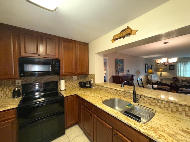 kitchen featuring backsplash, an inviting chandelier, black appliances, sink, and light tile patterned floors