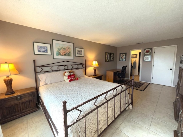 bedroom featuring light tile patterned floors and a textured ceiling