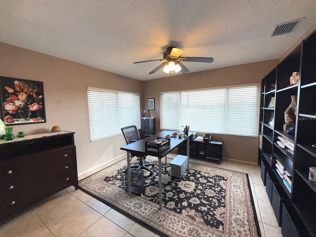 tiled home office with ceiling fan and a textured ceiling