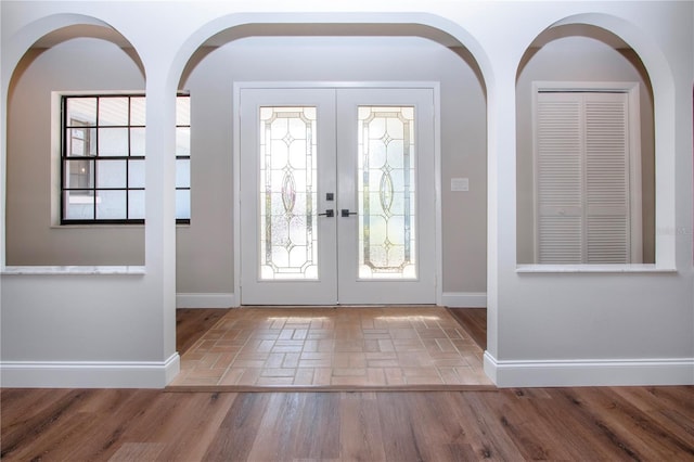 entrance foyer with french doors, hardwood / wood-style flooring, and a healthy amount of sunlight