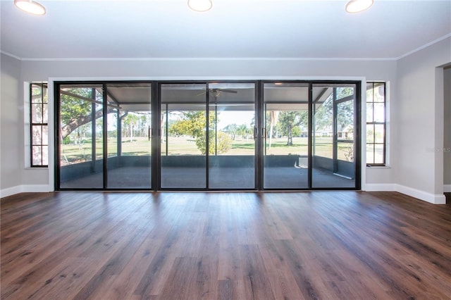 spare room with dark wood-type flooring, ceiling fan, and crown molding