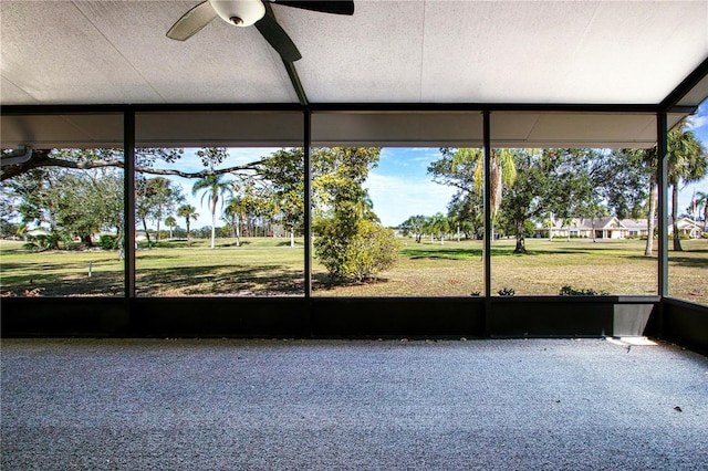 unfurnished sunroom featuring ceiling fan