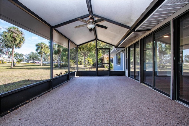 unfurnished sunroom featuring vaulted ceiling, a wealth of natural light, and ceiling fan