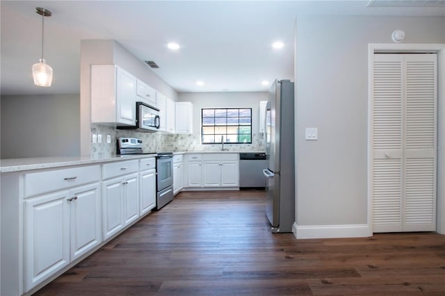 kitchen with white cabinetry, dark wood-type flooring, tasteful backsplash, decorative light fixtures, and appliances with stainless steel finishes