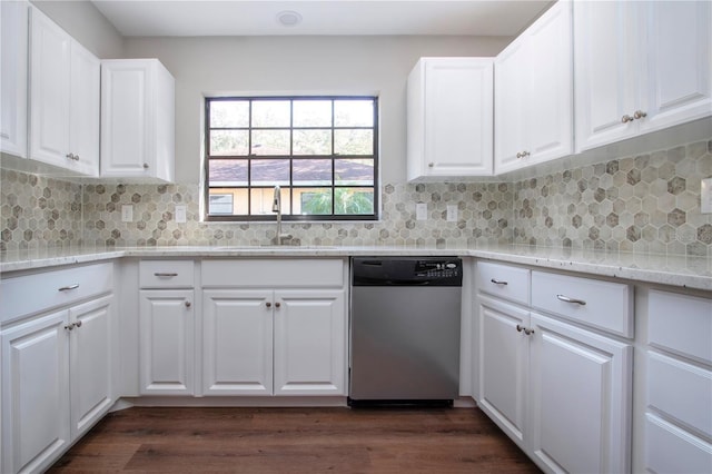 kitchen featuring stainless steel dishwasher, decorative backsplash, white cabinetry, and sink