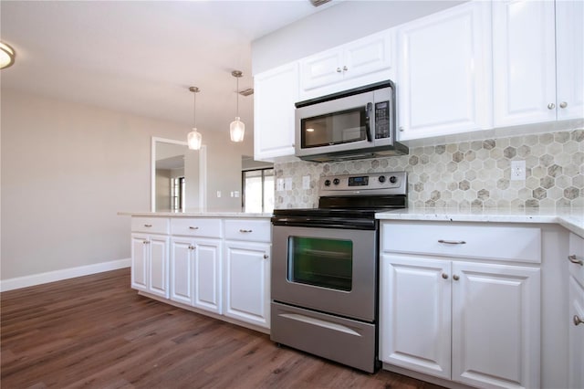 kitchen featuring appliances with stainless steel finishes, decorative light fixtures, and white cabinetry