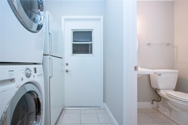 laundry room with light tile patterned flooring and stacked washer and clothes dryer