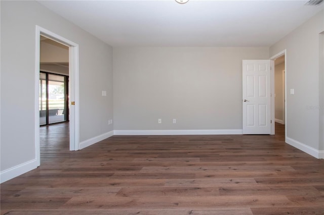 empty room with dark hardwood / wood-style flooring