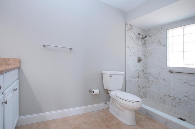 bathroom featuring tiled shower, tile patterned floors, vanity, and toilet