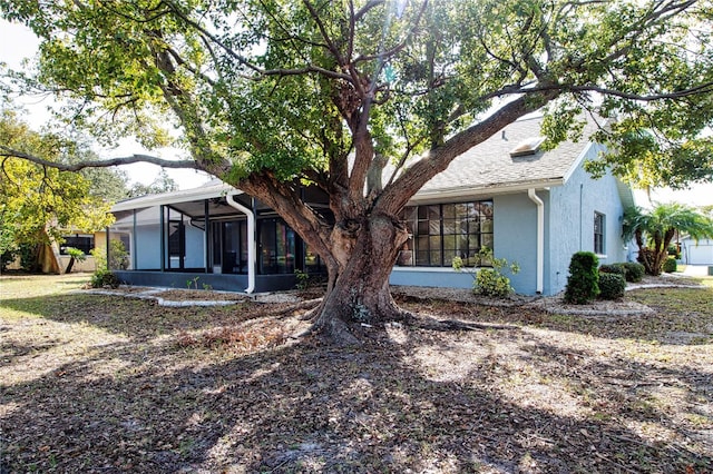 rear view of property featuring a sunroom