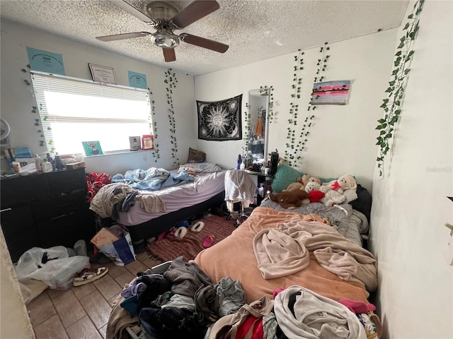 bedroom featuring ceiling fan and a textured ceiling