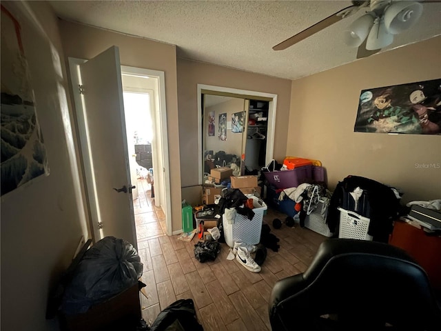 interior space with ceiling fan and a textured ceiling