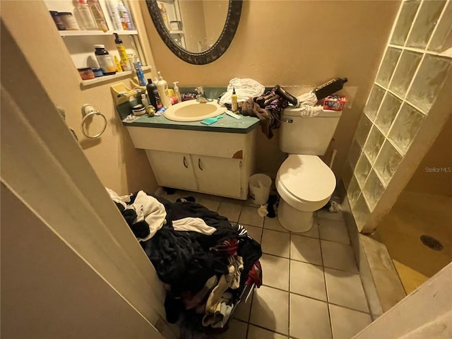 bathroom with tile patterned flooring, a shower, vanity, and toilet