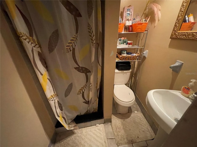 bathroom featuring sink, tile patterned flooring, and toilet