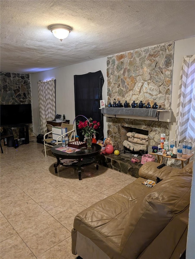 living room featuring tile patterned floors, a stone fireplace, and a textured ceiling