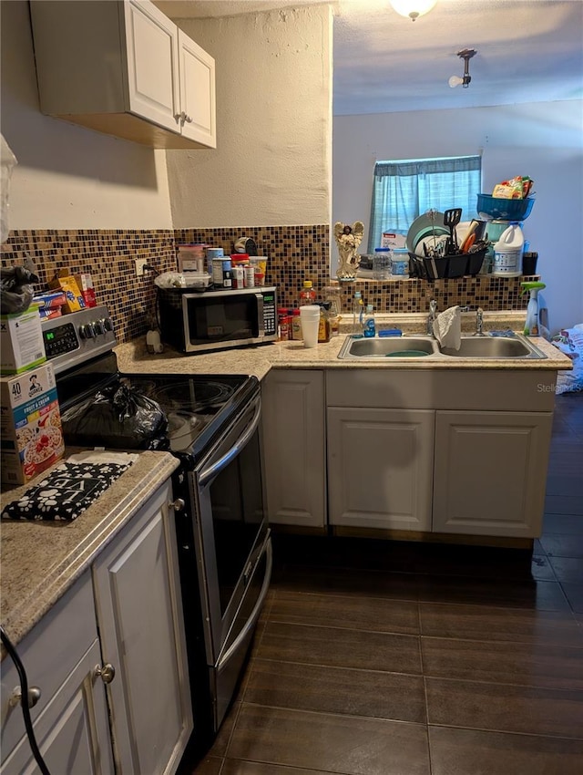 kitchen featuring stainless steel appliances, backsplash, dark wood-type flooring, and sink