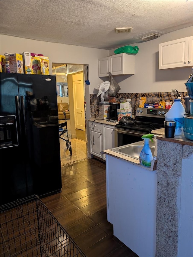 kitchen with dark hardwood / wood-style flooring, white cabinets, stainless steel range with electric cooktop, and black refrigerator with ice dispenser