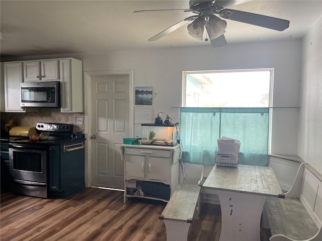 kitchen featuring white cabinetry, ceiling fan, dark hardwood / wood-style flooring, decorative backsplash, and appliances with stainless steel finishes