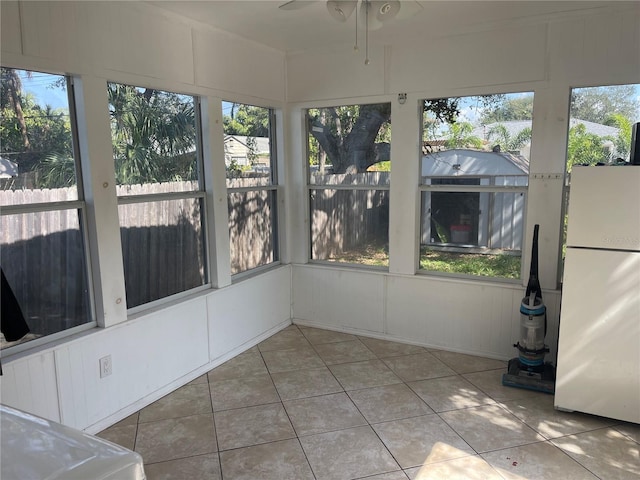 unfurnished sunroom featuring a wealth of natural light and ceiling fan