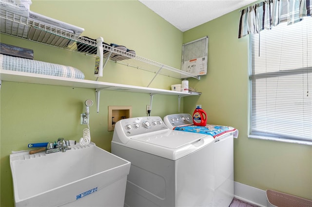 laundry area with separate washer and dryer, sink, and a wealth of natural light