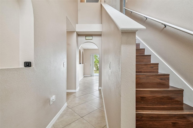 6213 Venezia Pl, Riverview, FL 33578 - stairs featuring arched walkways, a textured wall, and tile patterned floors