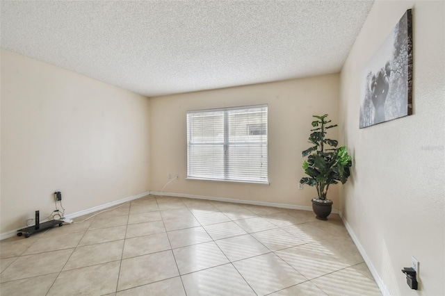 spare room with light tile patterned flooring and a textured ceiling