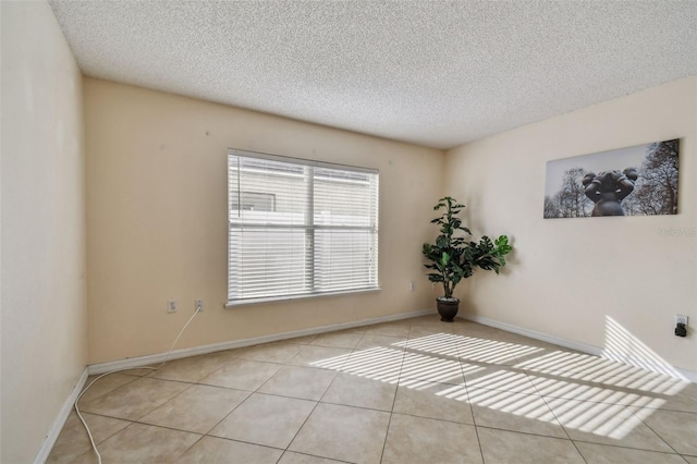 tiled empty room with a textured ceiling