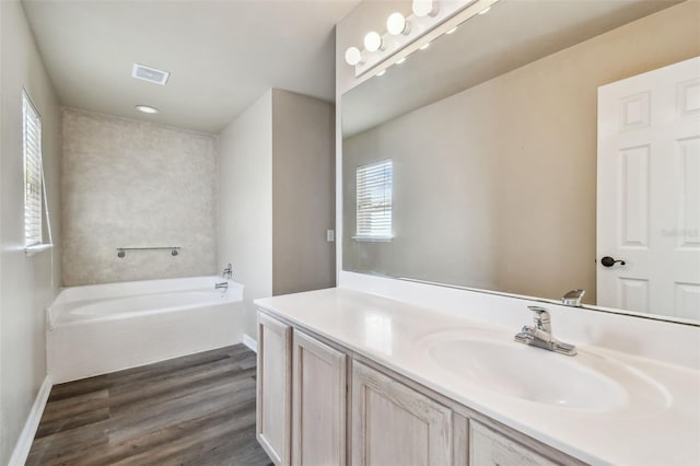 bathroom featuring a bathing tub, plenty of natural light, vanity, and hardwood / wood-style floors