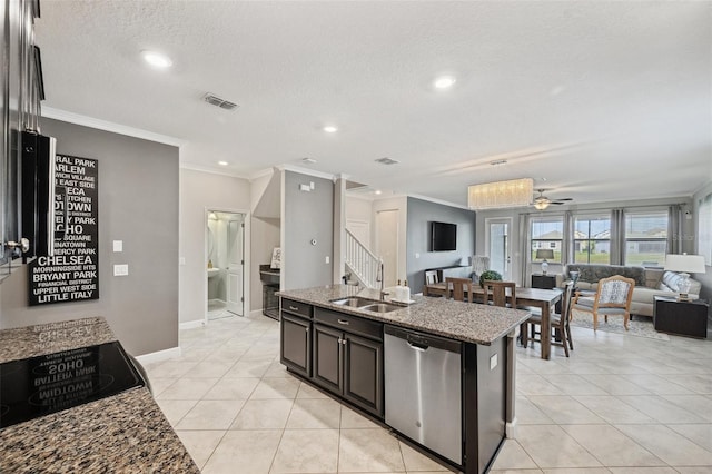 kitchen with ceiling fan, dishwasher, sink, light stone counters, and an island with sink