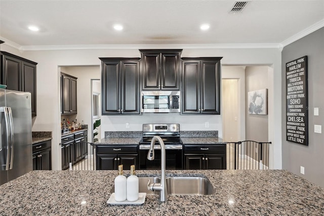 kitchen with light stone counters, crown molding, and stainless steel appliances