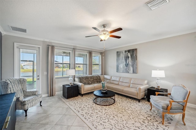 tiled living room featuring ceiling fan, ornamental molding, and a textured ceiling