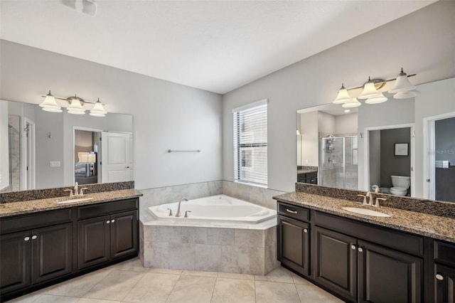 full bathroom featuring tile patterned floors, vanity, toilet, and independent shower and bath