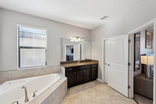 bathroom with vanity, tile patterned floors, and tiled tub