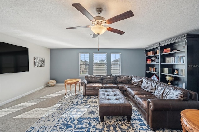 living room featuring ceiling fan, carpet floors, and a textured ceiling