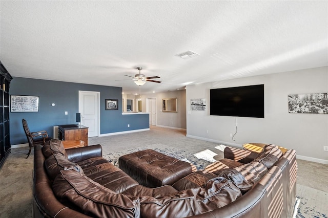 carpeted living room with a textured ceiling and ceiling fan