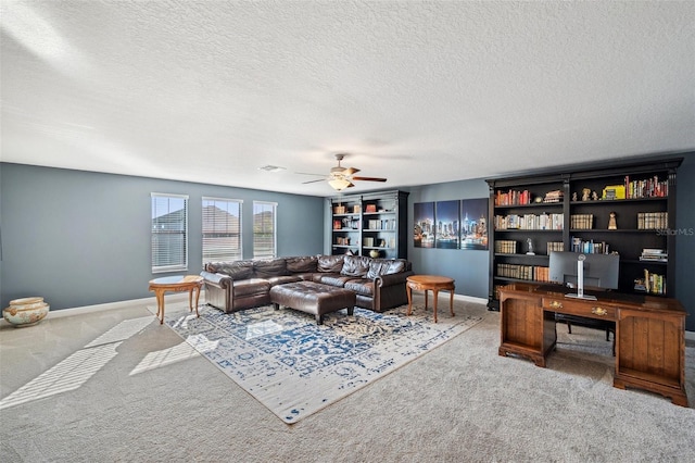 living room featuring a textured ceiling, carpet floors, and ceiling fan