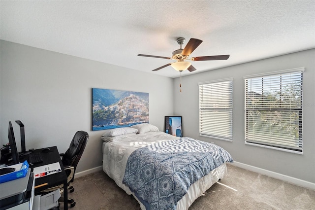 carpeted bedroom featuring a textured ceiling and ceiling fan