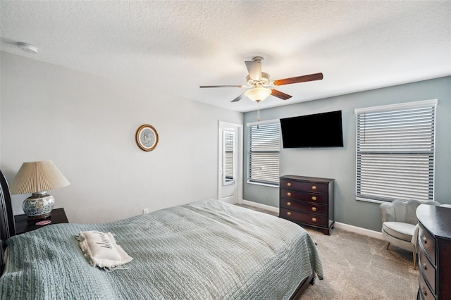 bedroom featuring light carpet, a textured ceiling, and ceiling fan