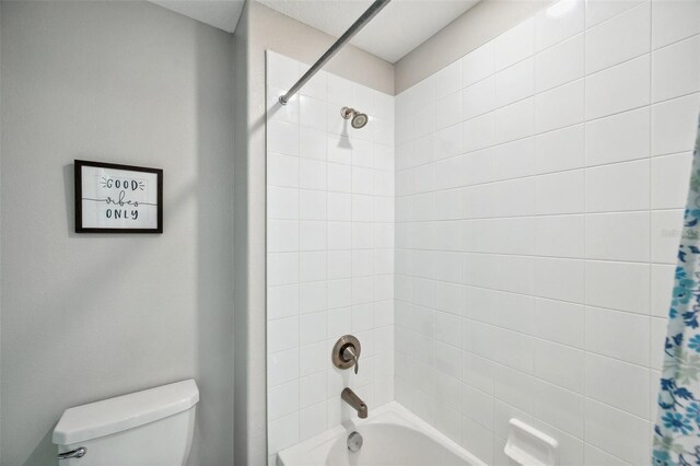 bathroom with shower / bath combination with curtain and toilet