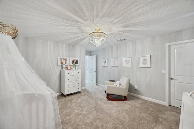 bedroom with a textured ceiling, a notable chandelier, and light carpet