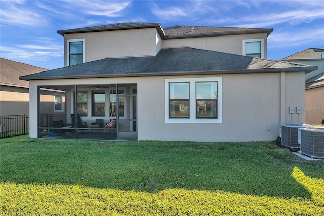 rear view of property featuring a yard, central AC, and a sunroom