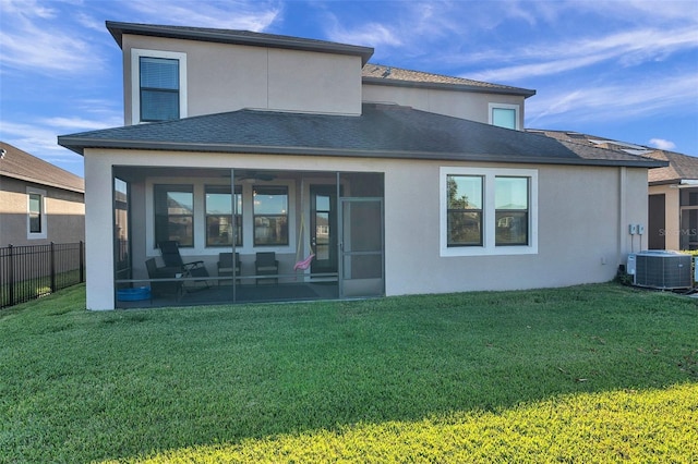 back of house featuring central AC, a sunroom, and a yard