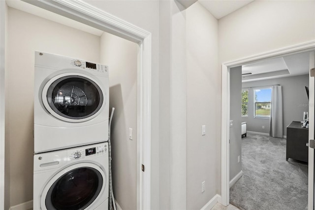 clothes washing area with stacked washing maching and dryer and carpet floors