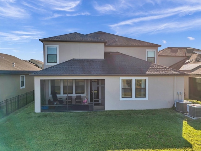 rear view of house featuring a yard, central air condition unit, and a sunroom