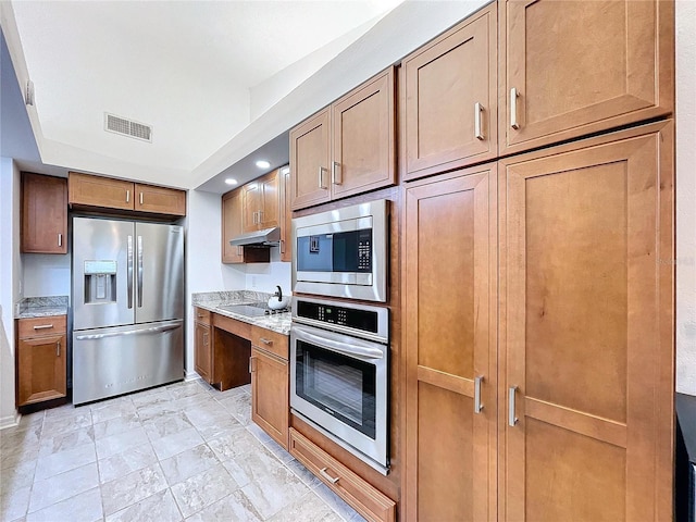 kitchen featuring light stone countertops and stainless steel appliances