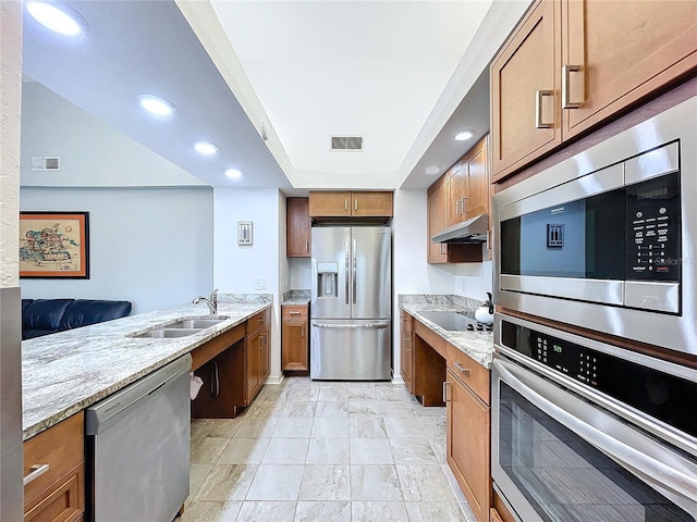 kitchen with light stone counters, sink, and stainless steel appliances