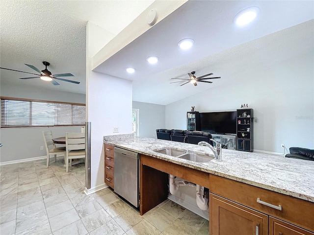 kitchen with stainless steel dishwasher, light stone countertops, sink, and a textured ceiling