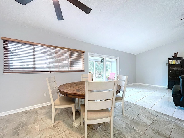 dining area featuring ceiling fan and a textured ceiling